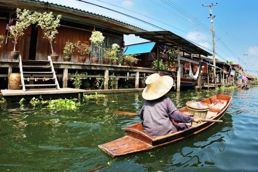 Lokale bevolking in huizen op palen langs de kanalen van Bangkok