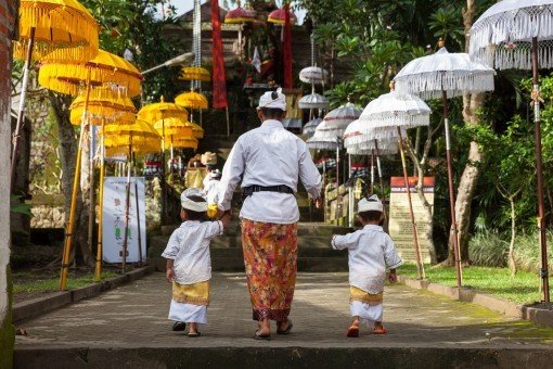 Vader en zoon in traditionele kleding op weg naar tempel