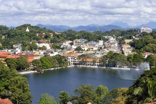 De stad Kandy met uitzicht over het meer, de bergen en het grote, witte Boeddhabeeld
